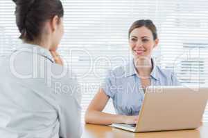 Businesswoman smiling at interview candidate