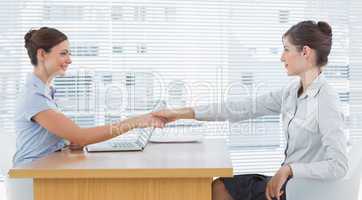 Businesswoman shaking hands with interviewee