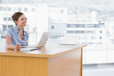Businesswoman smiling at her desk