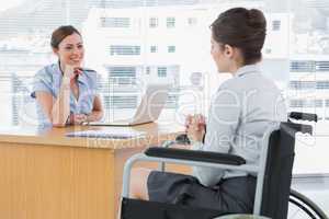 Businesswoman listening to disabled job candidate