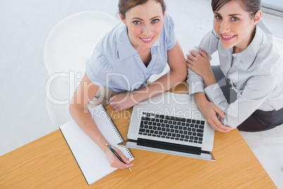 Businesswomen having a meeting and looking up at camera