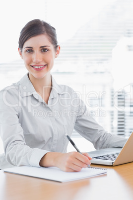 Pretty businesswoman working and smiling at camera