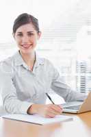 Pretty businesswoman working and smiling at camera