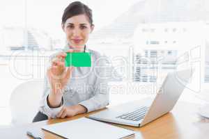 Happy businesswoman showing green business card