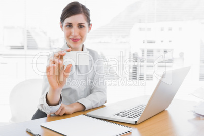 Happy businesswoman showing blank business card