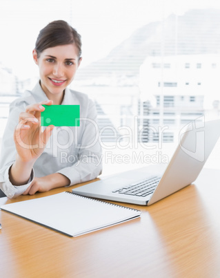 Pretty businesswoman showing green business card