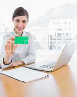 Pretty businesswoman showing green business card