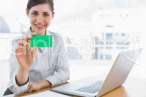 Young businesswoman showing green business card