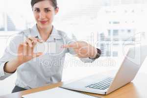 Young businesswoman pointing to blank business card