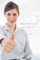 Portrait of a young businesswoman giving thumb up