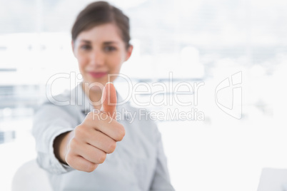 Young businesswoman giving thumb up and smiling