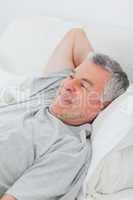 Cheerful man relaxing in bed