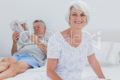 Mature woman sitting on bed