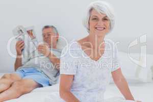 Mature woman sitting on bed