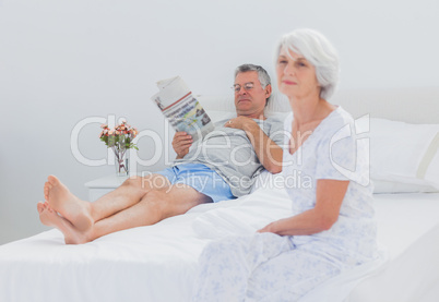 Mature woman sitting on bed