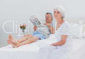 Mature woman sitting on bed