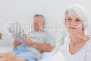 Smiling mature woman sitting in bed