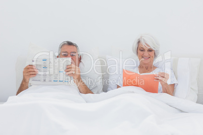 Mature people reading in bed