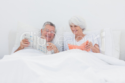 Mature man showing newspaper to his wife