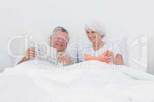 Mature man showing newspaper to his wife