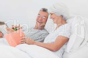 Woman showing her book to her husband