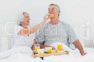 Woman giving husband a croissant