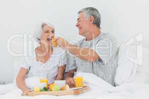 Man giving wife a croissant to wife