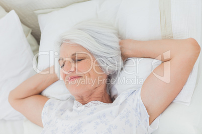 Peaceful woman relaxing in bed