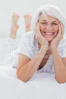 Woman posing while she is lying on bed