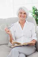 Woman holding a book and looking at camera