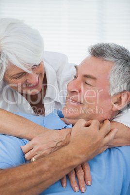 White haired woman hugging husband