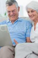 Couple using a laptop on the couch