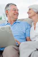Couple using a laptop pc on the couch