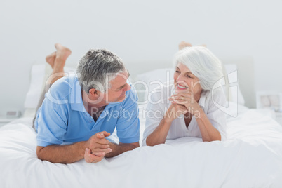 Couple lying and talking together in bed