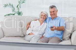 Couple watching television sitting on the couch