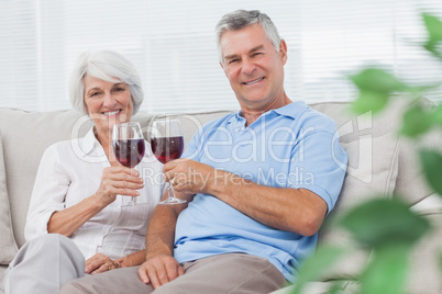 Couple clinking their red wine glasses