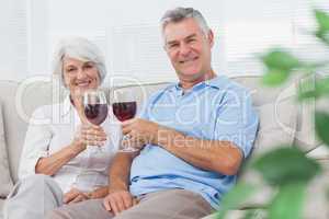 Couple clinking their red wine glasses