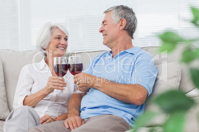 Couple clinking their glasses of red wine