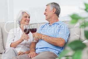 Couple clinking their glasses of red wine