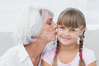 Grandmother kissing her cute granddaughter