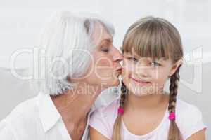 Grandmother kissing her cute granddaughter