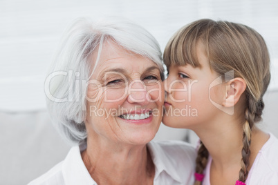 Cute little girl kissing her grandmother