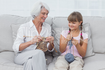 Granddaughter learning how to knit with grandmother