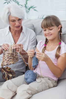 Little girl and her granddaughter knitting together