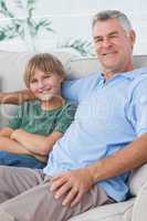 Portrait of grandson and grandfather sitting on the couch