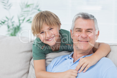 Portrait of grandson embracing grandfather