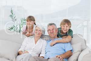 Grandchildren and grandparents sitting on couch