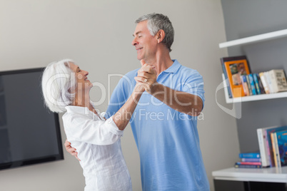 Elderly couple dancing in the living room