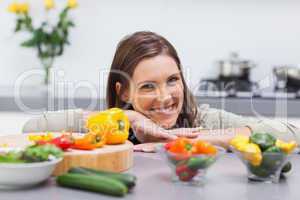 Cheerful woman leaning on the counter of her kitchen