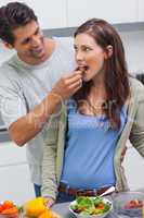 Man feeding his wife cherry tomato